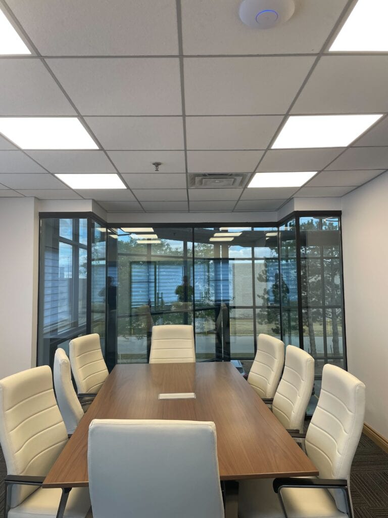 Boardroom with recessed LED panel lighting after a commercial office renovation
