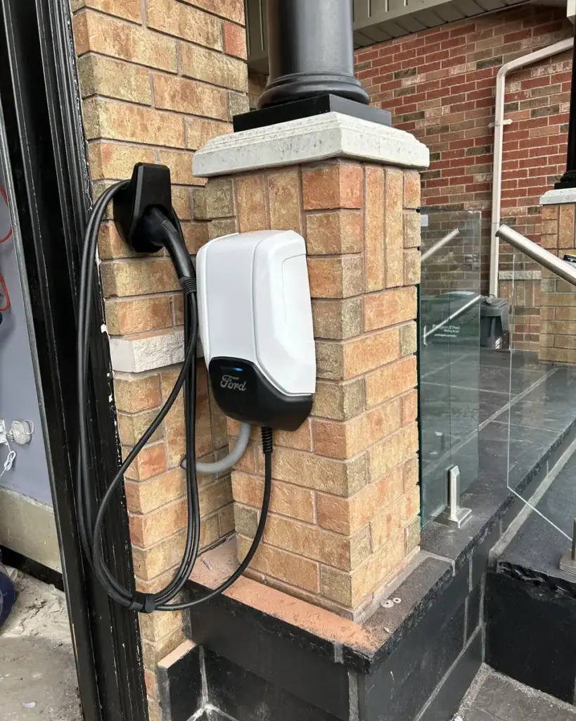 Level 2 EV charger installed on an exterior brick column by Padi Electric
