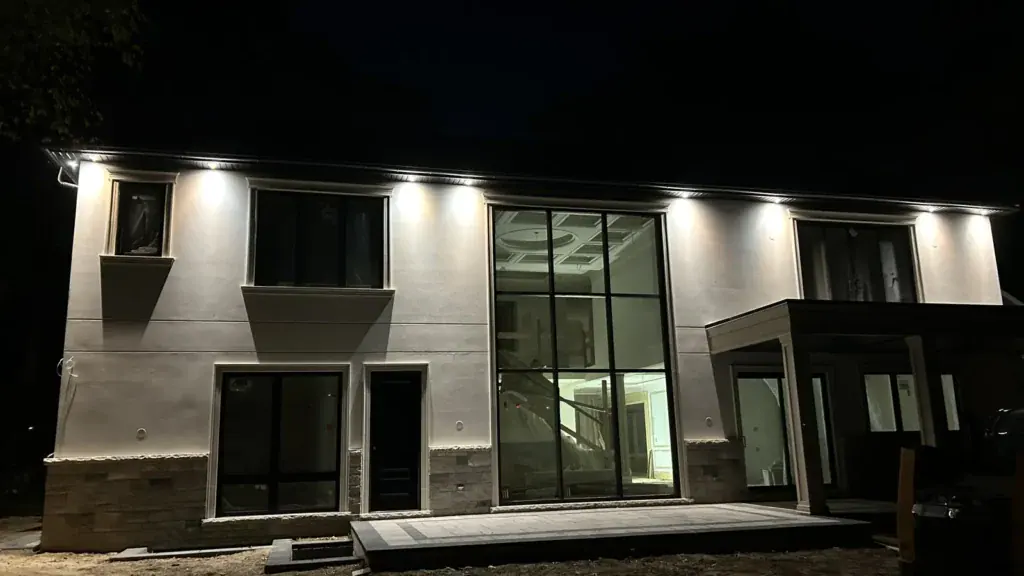 Custom new home at night with exterior soffit lighting wired by Padi Electric